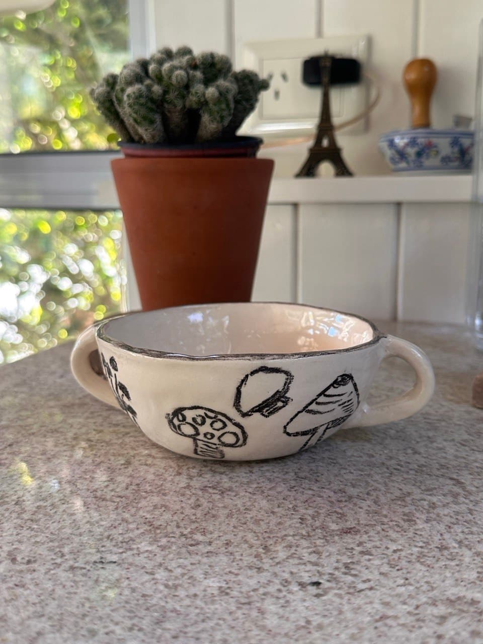 El Cuenco Humus en casa de Cali, junto a una maceta con un cactus