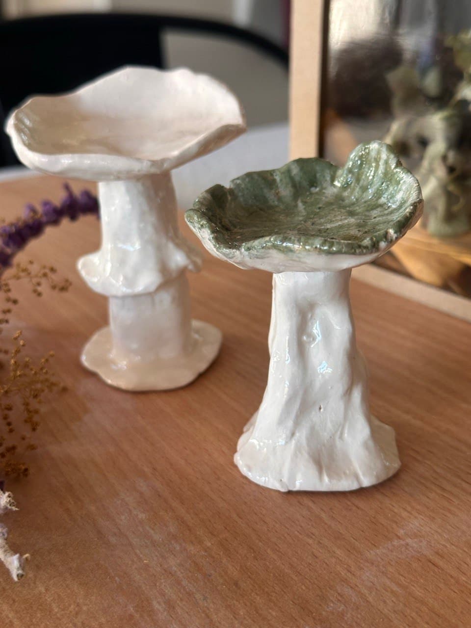 Los mismos dos hongos vistos de cerca: el de sombrero verde con el borde ondulado y el blanco con su pollerita en el tallo