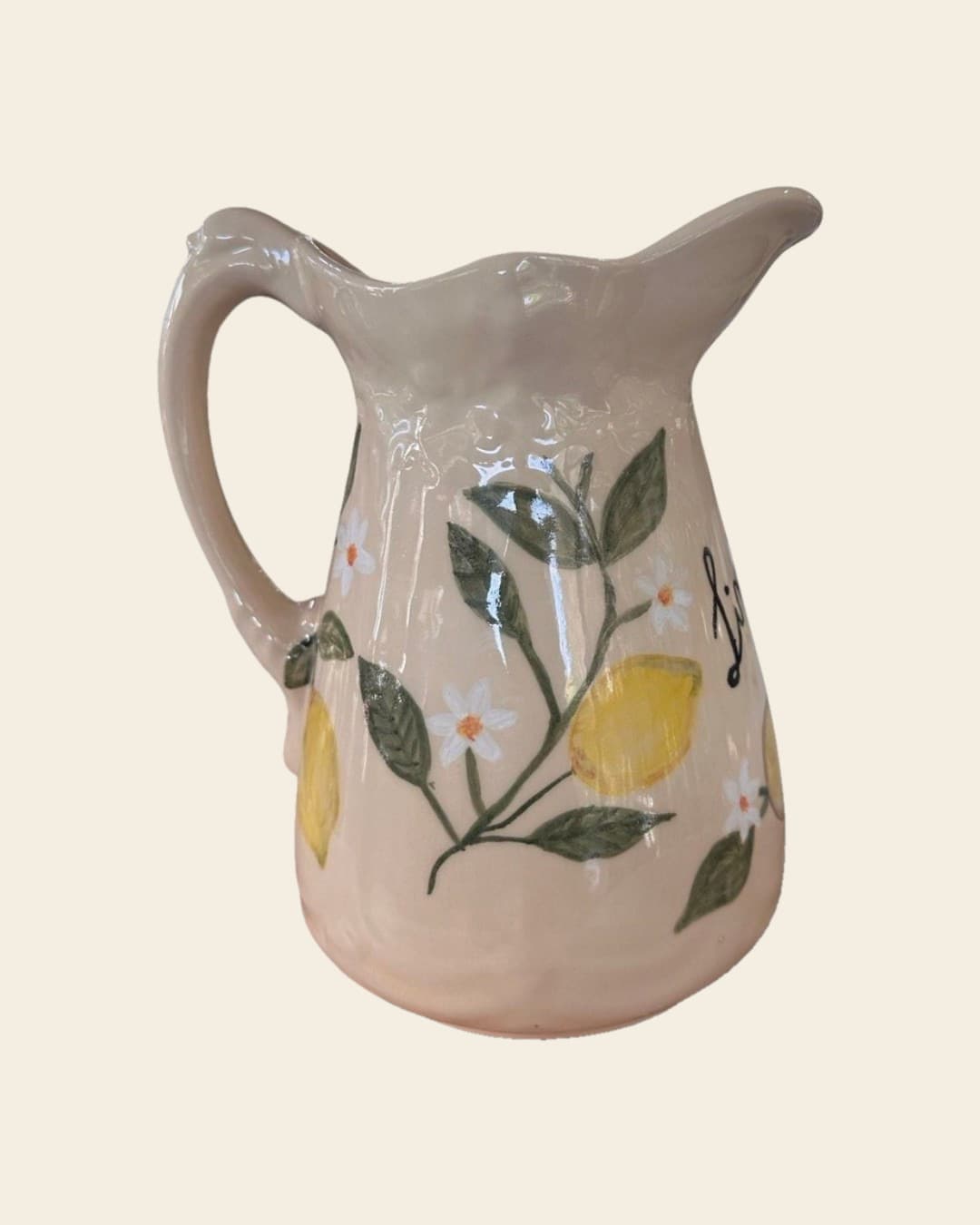 Jarra de cerámica color manteca con borde ondulado, limones amarillos en relieve, hojas verdes y flores de azahar pintadas a mano; de costado asoma la palabra Limonare escrita en cursiva
